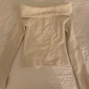 Offshoulder beige stickad tröja 💛 - Superfin offshoulder stickad tröja från HM i beige med ribbat mönster. Tröjan har långa ärmar och en bred vikt tygbit som ligger på axlarna💛Endast använd 1 gång