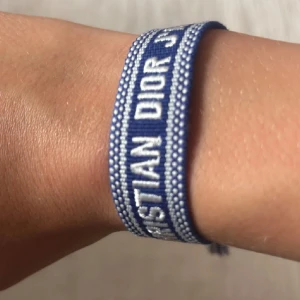 Blått Christian Dior armband - Säljer ett stilrent lyxigt armband från Christian Dior för en billig peng, armbandet har två snören där man kan justera storleken. Köp en för 149kr eller fem för 499kr Kontakta mig vid frågor!