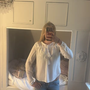 Vit blus med spetsdetaljer - Säljer en vit blus med långa ärmar och spetsdetaljer