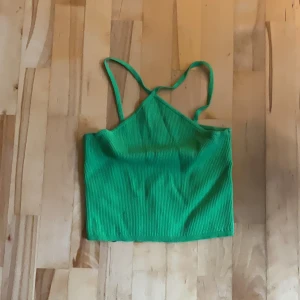 Grön ribbad linnetopp från H&M - Snygg grön ribbad linnetopp från H&M med smala axelband och croppad passform. Toppens material är stretchigt och mjukt och sitter väldigt skönt.