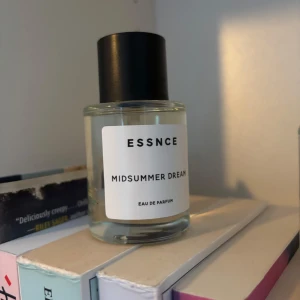ESSNCE Midsummer Dream parfym - Fräsch parfym från ESSNCE med namnet Midsummer Dream. Flaskan är rund och genomskinlig med svart lock och vit etikett med minimalistisk design. Eau de Parfum som ger en modern och stilren känsla. Ny