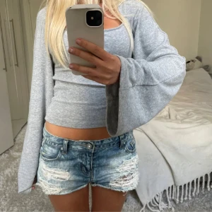 Blå slitna jeansshorts med fransar - Säljer ett par blå jeansshorts med slitna detaljer och fransig nederkant. Shortsen har klassisk femficksmodell, låg midja och dragkedja med knapp. Perfekta för sommardagar och ger en cool, avslappnad vibe. Det är bara skriva vid frågor!! Det är tjejen jag köpte dom från på bilderna!❤️