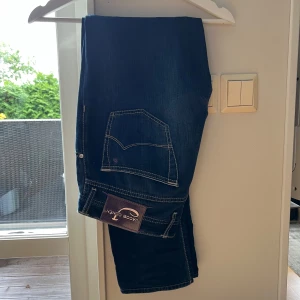Jacob Cohen Jeans  - Ett par mörkblå Jacob Cohen jeans i storlek 32, passar mig som är 185cm lång! Dem har en lagning mellan benen som en skreddare har gjort så det är ingenting som syns! 