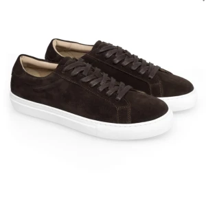 Mörkbruna mockasneakers - Les Deux - Stilrena sneakers i mörkbrun mocka med klassisk vit platt sula. Skorna har rund tå, snörning och diskreta sömmar som ger en clean look. Perfekta för dig som gillar minimalistisk stil med en twist av lyxig mocka. Från Les Deux.