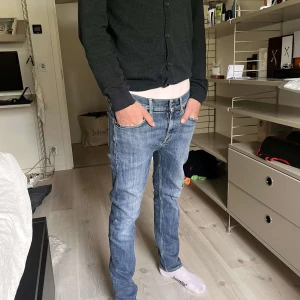 Tiger of Sweden ljusblå jeans - Säljer ett par ljusblå jeans från Tiger of Sweden, modell Leon. Jeansen har raka ben, klassisk femficksdesign och snygga detaljerade bakfickor. Tillverkade i bomull med en skön passform som sitter snyggt på benen.