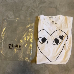 Vit t-shirt Comme des Garçons Play - Säljer denna T-shirten av Comme des Garçons Play då den tyvärr var för liten. Den är helt nytt skick! Priset är inte hugget i sten så kom med bud!