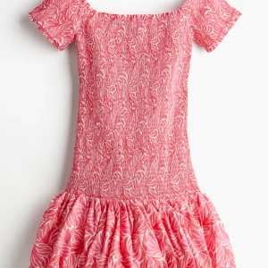 Rosa kortklänning med mönster - Säljer denhär fina off-shoulder klänningen från H&M. Använt 3-4 gånger. Skriv för fler bilder✨