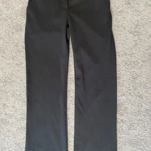 Svarta kostymbyxor - Klassiska svarta kostymbyxor från 157 med raka ben. Byxorna har knapp och dragkedja framtill samt sidfickor. Perfekta för en clean och stilren look😇Liten fläck på baksidan vid midjan men annars i väldigt bra skick! 