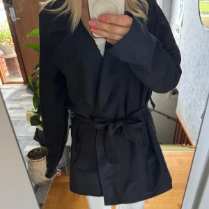 Svart trenchcoat  - Snygg svart trenchcoat perfekt till våren, hösten och sommarkvällar. Jackan har en rak passform och långa ärmar, perfekt för att göra outfiten mer elegant och tidslös. Stilren enkel design som funkar till många outfits. 💕