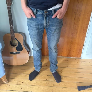 Blå slim jeans från nudie modell lean dean - Skitsnygga ljusblå nudie jeans i strl 28/30. Defekt-lite trasig innerficka men inget som är synligt. Nypris ligger på runt 1400kr