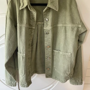 Grön jeansjacka från Zara  - Snygg ljusgrön jeansjacka från Zara i storlek XS. Jackan har klassisk krage, tryckknappar framtill och två stora fickor. Tillverkad i bomull, perfekt för lager-på-lager och chill stil. Passar dig som gillar en avslappnad look.