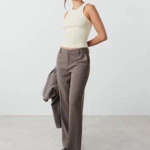 Bruna PETITE kostymbyxor Straight - Snygga bruna kostymbyxor med hög midja och raka, vida ben. Byxorna har pressveck, hällor för bälte och diskreta fickor. Perfekta för en clean och stilren look. Byxorna är använda av mig men har inga tecken på användning, bytt storlek på alla kläder nu, bilder där jag har på mig dem eller närbilder kan absolut skickas 🤎 Köpte dem för 499kr från Gina Tricot. Har tyvärr inte kvittot kvar. Priset kan diskuteras, vill att de ska komma till användning. OBS BILDEN DÄR JAG HAR DE ÄR DE FÖR STORA FÖR MIG