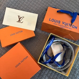 Svart Louis Vuitton skärp med LV-spänne - Exklusivt svart skärp från Louis Vuitton.helt ny och oanvänd.Levereras med originalbox, dustbag och certifikat/kvitto band och en metall pinne man kan göra egna hål med.