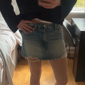 Ljusblå jeanskjol med slitningar - Säljer en kort ljusblå jeanskjol med snygga slitningar och fransig nederkant. Kjolen är i mycket bra skick och är endast använd fåtal gånger.