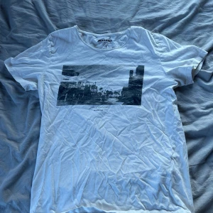 Vit t-shirt med print från Jack & Jones - Vit t-shirt från Jack & Jones med svartvit grafiskt print framtill. Sparsamt använd, storlek s
