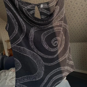 Svart mönstrad topp - Superfint linne. har en snygg draperad halsringning.