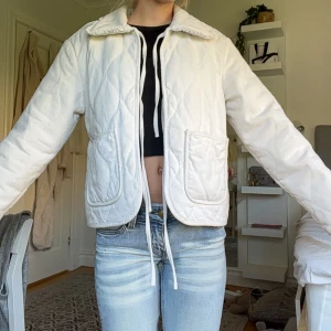 Vit jacka med knyt band  - Superfin vår/sommar jacka från vero Moda i ljusvit färg med volangdetaljer på kragen och stora fickor framtill. Jackan har aldrig använts så den är som ny!! 