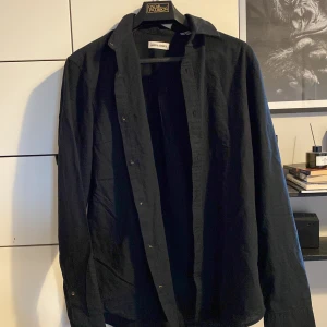 Svart skjorta från Jack & Jones XS - Passar någon runt 180-186 - är stor i storleken helt ny köpte den i förrgår.     NYPRIS:449 kr                   Svart långärmad skjorta från Jack & Jones i klassisk modell. Skjortan har knappar framtill och är tillverkad i mjuk bomull. Perfekt för dig som gillar en stilren och enkel look.