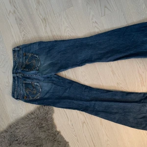 Blå bootcut jeans från S.Oliver - Snygga blå bootcut jeans från S.Oliver med detaljer på bakfickorna. Passformen är lite mer baggy 