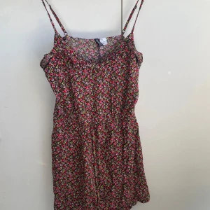 Blommig sommarklänning  - Söt blommig klänning med smala axelband och färgglatt mönster i rosa, rött, grönt och vitt. Perfekt för varma dagar och har en luftig passform som ger en avslappnad känsla. står storlek 40 men upplever den mer åt 38. 