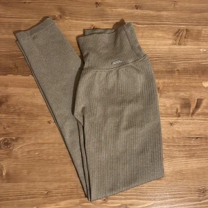 Aim’n tights - Supersnygga ribbade leggings i beige med hög midja och bred linning. De är stretchiga och sitter tight, perfekta för en chill look eller till träning. Materialet känns mjukt och följsamt mot kroppen.