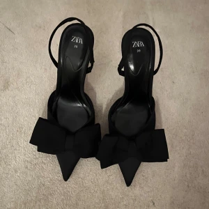 Svarta klackskor med rosett från Zara - Jätte snygga svarta klackskor från Zara med spetsig tå och en stor rosett framtill! Storlek 39💞🙌🏼🥰endast använda fåtal ggr