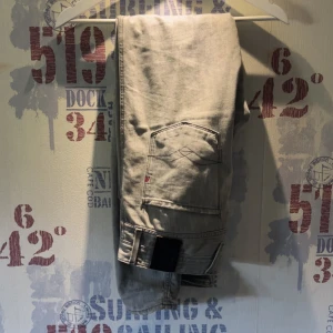 Ljusgråa jeansbyxor från Replay Anbass - Säljer ett par ljusgråa Replay Anbass jeans med klassisk femficksdesign och raka ben. Byxorna har en diskret logga på fickan och är i storlek 32. Perfekta för dig som gillar stilrena och bekväma jeans.