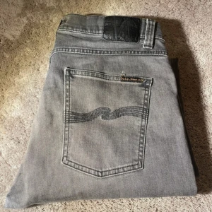 Gråa Nudie Jeans lean dean - Tja! Säljer mina gråa jeans från Nudie, modellen heter lean dean och är i en slim fit passform.  Storlek 31/32. Superfint skick (9/10). Använda fåtal gånger. Perfekta nu under våren/sommaren. Skönt mjukt och strechigt material, jeansen är även  tillverkade i ekologisk bomull. Kvitto finns! Nypris är ca 1800:-. Helt slutsålda överallt. Tveka inte att höra av er vid fler frågor eller funderingar! Vid snabb och enkel affär= släpper billigare