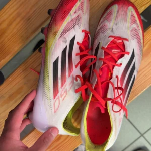 Adidas F50 fotbollsskor med röda detaljer - Säljer ett par Adidas F50 Elite fotbollsskor. Storlek 43/1,3 , använda ett par matcher på konstgräs. Inte trasiga bara smutsiga