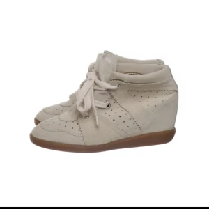 Isabel Marant sneakers beige - Säljer ett par jättefina äkta beiga sneakers med kilklack från Isabel Marant.💕 Skorna är i mocka med perforerade detaljer och har snörning framtill. Köpte på sellpy förra året men har aldrig kommit till användning. 💓De är i storlek 40 men passar även mig som vanligtvis har 39. Hör av er vid frågor!!💗💗