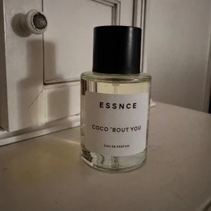 ESSNCE Coco 'Bout You Eau de Parfum - En stilren parfymflaska med transparent glas och svart lock. Doften heter Coco 'Bout You och är en Eau de Parfum. Endast testsprutad