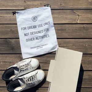  Golden Goose skor - Säljer ett par vita sneakers från Golden Goose med grå stjärndetalj på sidan och svarta hälpartier. Perfekta inför sommaren. Skorna har grå snörning och platt sula. Skorna är i ett väldigt bra skick. Det är ansvönda men har mycket kvar och ge. Pris kan såklart diskuteras.🌟