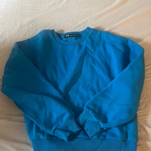 Blå sweatshirt från New yorker  - En enkel och stilren blå sweatshirt från New yorker i storlek XL men passar som M/L. Tröjan har rund halsringning, långa ärmar och breda muddar vid ärmslut och nederkant. Perfekt för en avslappnad och bekväm stil.