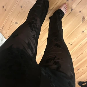 Svarta trendiga byxor med blommigt mönster från Rita Ora strl M, 90kr, oanvända - Snygga svarta byxor i sammet från Rita Ora med diskret blommigt mönster. Strl M, oanvända, 90kr