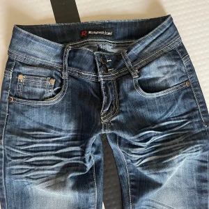 Lågmidjade jeans - Snygga blå lågmidjade jeans. Fickor med nitar och dekorativa paljetter baktill ger extra stil. Skriv privat för fler bilder eller frågor.❤️