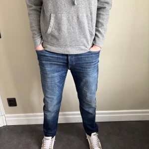 Blå jeans från jack&jones - Säljer ett par klassiska blå jeansbyxor med normal passform och raka ben. Jeansen har fem fickor, dragkedja och knapp i midjan. Perfekta för dig som gillar en tidlös stil.