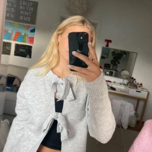 Ljusgrå kofta med knyt från Pieces - Superfin ljusgrå ribbad kofta från Pieces med två knyt framtill. .