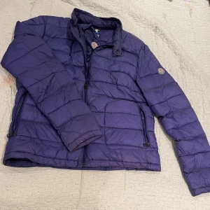 Lila dunjacka från Moncler - Säljer en vintage lila dunjacka från Moncler 🚨 Den har en klassisk quiltad design och hög krage. Jackan har dragkedja framtill, två sidofickor med dragkedja och Moncler-logga på ärmen. Den är storlek 50, alltså M-L.                                               Om du önskar fler bilder kom DM, pris kan diskuteras!💯💯