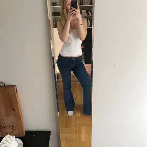 Mörkblå bootcut jeans - Säljer ett par mörkblå bootcut jeans med normal passform. Jeansen har låg midja och är tillverkade i ett stretchigt denimtyg, knappt använda 🤍