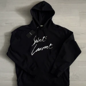 Saint Laurent hoodie - Riktigt fet svart YSL hoodie med vit tryck i storlek L. Helt oanvänd med lappen kvar💯 Mer frågor privat!🙏
