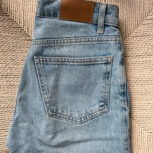 Ljusblå jeansbyxor från Gina Tricot - Säljer ett par klassiska ljusblå jeansbyxor från Gina Tricot med fem fickor och normal passform. Jeansen har en snygg tvätt, raka ben och traditionell knapp- och dragkedjestängning.