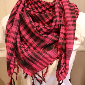 Palestina sjal Rosa och svart rutig halsduk - Säljer en snygg halsduk i rosa och svart med rutigt mönster och tofsar i kanterna. Perfekt accessoar för att liva upp din outfit och hålla dig varm under kyliga dagar.
