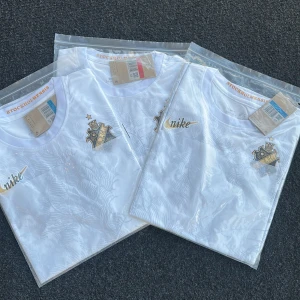 Vit t-shirt från Nike x AIK - Säljer en fräsch vit t-shirt från Nike i samarbete med AIK. T-shirten har AIK:s klubbmärke på bröstet och Nike-logga i guld. Klassisk rund hals och korta ärmar. Perfekt för dig som vill representera AIK med stil.