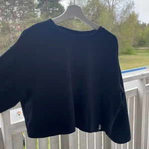 Svart croppad sweatshirt från Le Don De Vie - Säljer en svart croppad sweatshirt från Le Don De Vie i storlek XS. Tröjan har en enkel design med rund halsringning och långa ärmar. Perfekt för en avslappnad och stilren look.