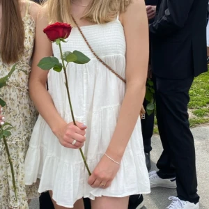 Vit sommarklänning  - Superfin vit klänning från Zara i storlek S. Klänningen är ärmlös med smock upptill och har en luftig, kort modell. Perfekt för varma dagar och enkel att styla med accessoarer. Axelbanden är tunna och går att ändra längd på. Materialet känns lätt och bekvämt.