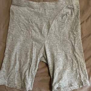 Grå cykelshorts i bomull - Gråa cykelshorts i mjukt och stretchigt bomullsmaterial. De har en enkel design utan synliga detaljer och en normal passform med midja som sitter bekvämt. Perfekta för sommarens alla aktiviteter.