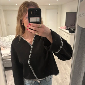 Svart jacka  - Svart croppad cardigan jacka med vita kontrastsömmar längs kanterna. Säljer pga att den aldrig kommit till andvändning💕