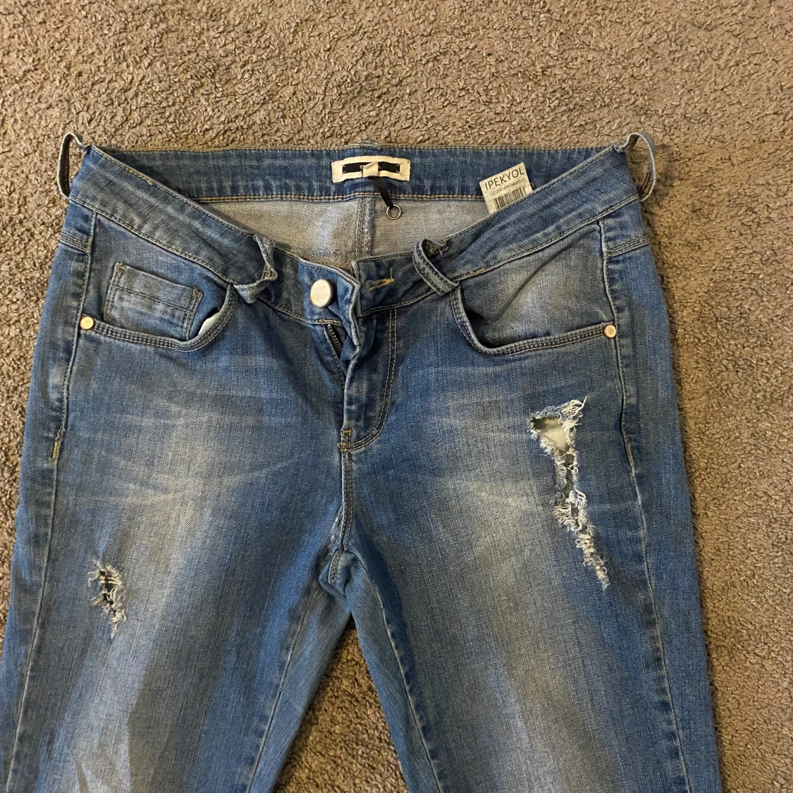 Låg midjade blå bootcut jeans med slitningar  - 1