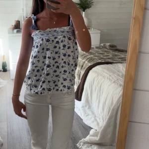 Vit och blå blommig linnetopp med knytband - Säljer en söt vit linnetopp med blått blommönster och knytband på axlarna🌊🫧🤍☀️