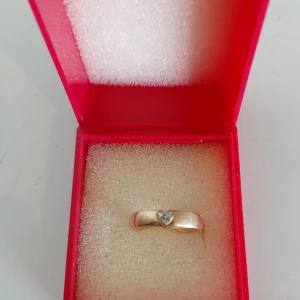 Guldring  - Guldring i 18 karat guld med små stenar. Vet tyvärr inte mått men den passar nog de flesta. Har aldrig använt den men fått av min mor. Pris diskuterbart 